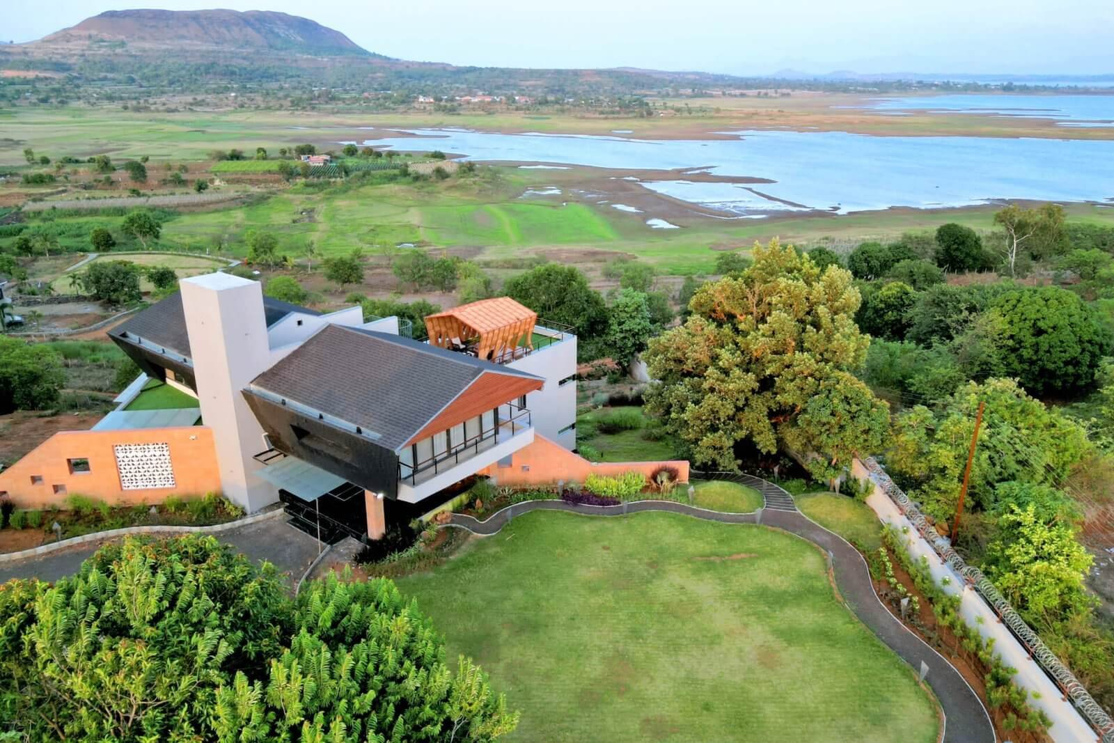 EXTERIOR · DRONE – Full property at twilight, lake in background.